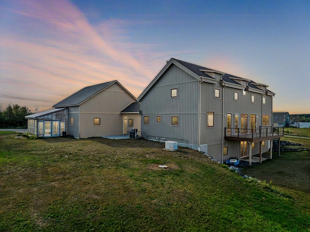 property exterior at dusk featuring cooling unit and a lawn