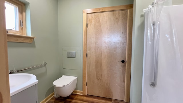 bathroom featuring hardwood / wood-style floors, curtained shower, vanity, and toilet