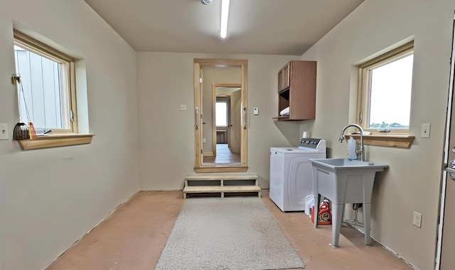 clothes washing area featuring cabinets, sink, and washing machine and dryer