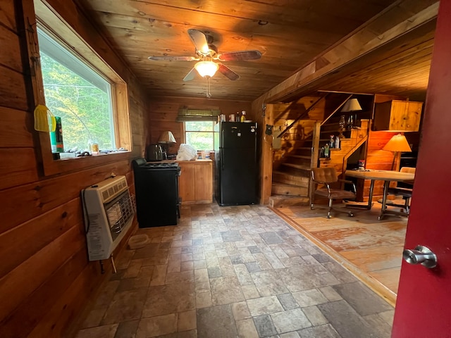 interior space with wood ceiling, heating unit, wood walls, and ceiling fan