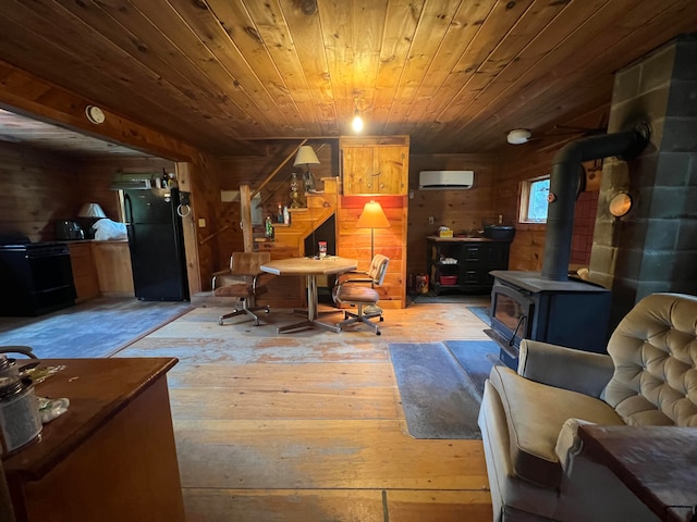 office space featuring wood ceiling, a wood stove, light wood-type flooring, and wooden walls