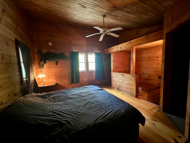 bedroom featuring ceiling fan, wood walls, wood-type flooring, and wooden ceiling