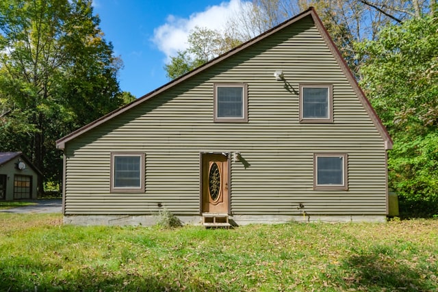 rear view of house featuring a lawn