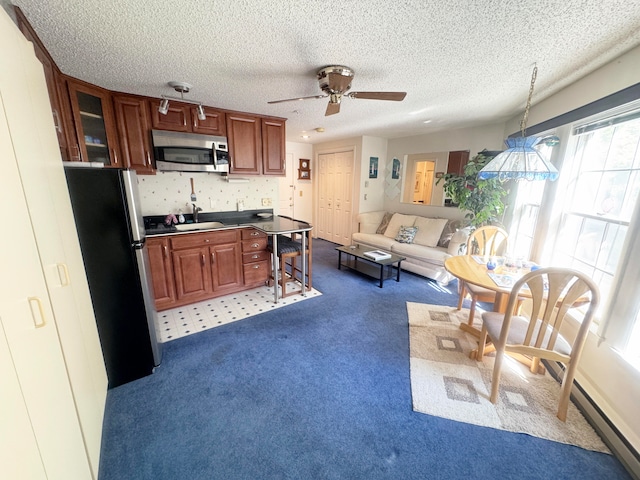 kitchen with ceiling fan, pendant lighting, sink, a textured ceiling, and appliances with stainless steel finishes