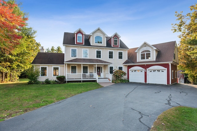 view of front of property with a garage, a front yard, and covered porch