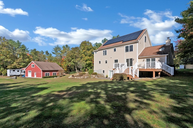 back of property with a wooden deck and a lawn