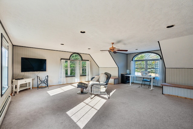 living room featuring light carpet, baseboard heating, ceiling fan, and a textured ceiling