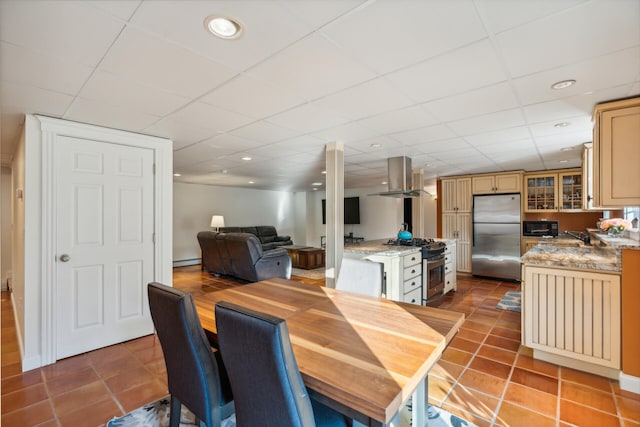 tiled dining space featuring a drop ceiling and a baseboard heating unit