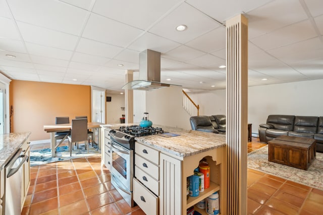 kitchen with light tile patterned flooring, island exhaust hood, decorative columns, white cabinets, and appliances with stainless steel finishes