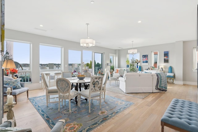 dining space featuring light wood-type flooring and a chandelier