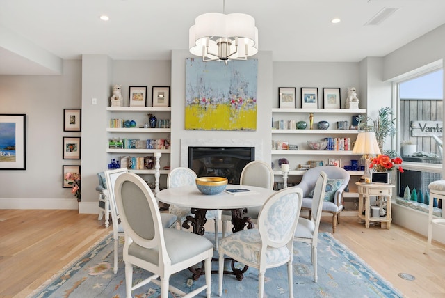 383 Commercial St Unit 701, Portland, ME 04102 - dining area with a glass covered fireplace, a notable chandelier, recessed lighting, visible vents, and wood finished floors