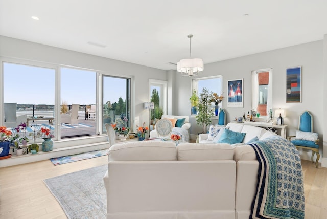 living room with a chandelier and light wood-type flooring