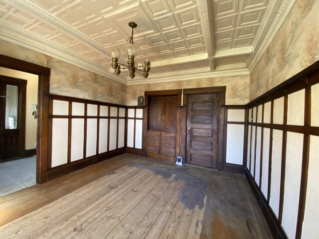 spare room featuring hardwood / wood-style floors and a chandelier