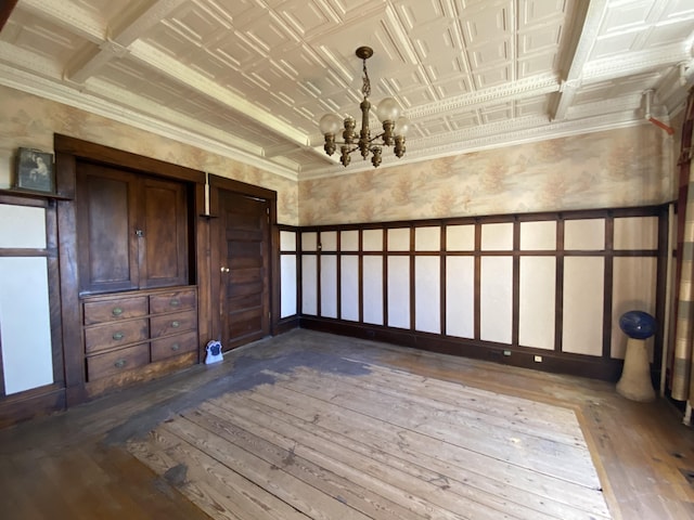 interior space featuring wood-type flooring, an inviting chandelier, and beamed ceiling