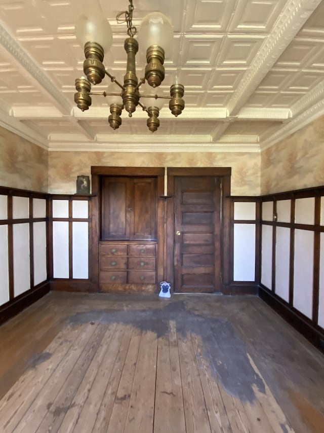 interior space with beamed ceiling, wood-type flooring, a chandelier, and coffered ceiling