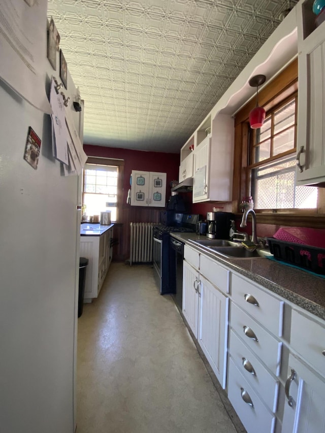 kitchen featuring white cabinets, sink, radiator heating unit, and black appliances