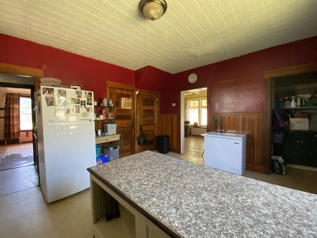 kitchen featuring refrigerator, radiator, white refrigerator, and plenty of natural light