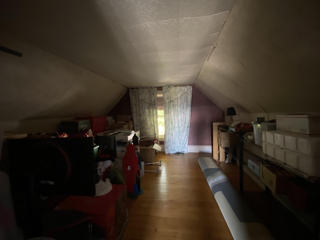 additional living space featuring lofted ceiling and hardwood / wood-style floors