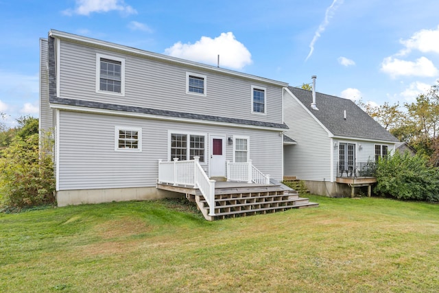 back of house featuring a lawn and a deck