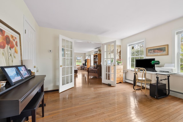 office area with french doors, light wood-type flooring, and a healthy amount of sunlight