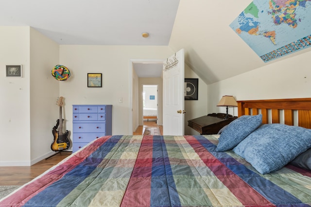 bedroom with vaulted ceiling and hardwood / wood-style flooring