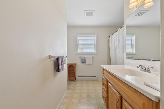 bathroom featuring a baseboard heating unit, a wealth of natural light, and vanity