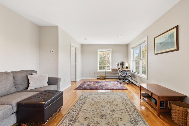 home office featuring light wood-type flooring and a baseboard heating unit