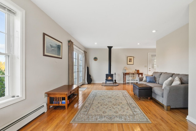 living room featuring light hardwood / wood-style floors, a wealth of natural light, and a baseboard radiator