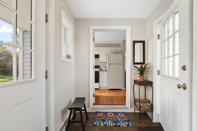 doorway to outside with dark tile patterned flooring