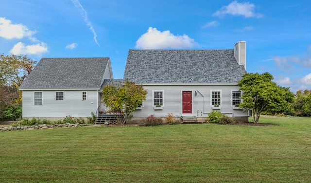 rear view of property featuring a lawn