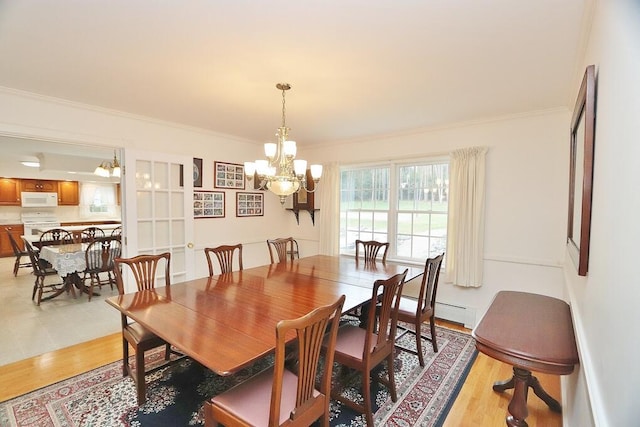 dining room featuring light hardwood / wood-style floors, a notable chandelier, and ornamental molding