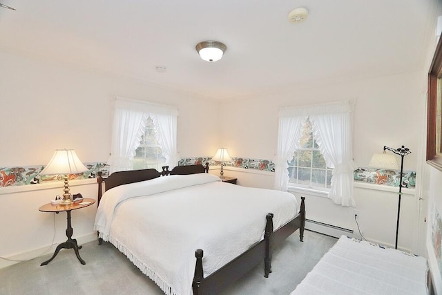 bedroom with multiple windows, baseboard heating, and light colored carpet