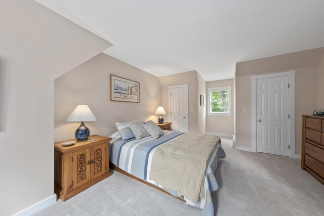 bedroom with light carpet and a closet