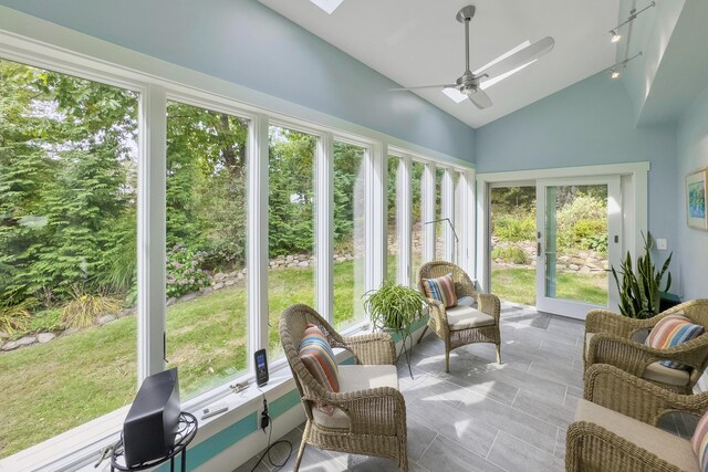 sunroom featuring a wealth of natural light, ceiling fan, and vaulted ceiling with skylight