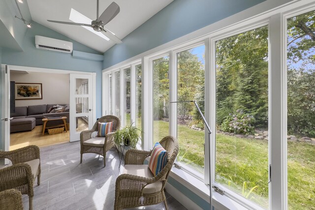 sunroom with vaulted ceiling, an AC wall unit, and ceiling fan