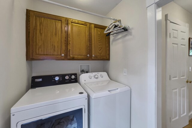 washroom featuring cabinets and separate washer and dryer