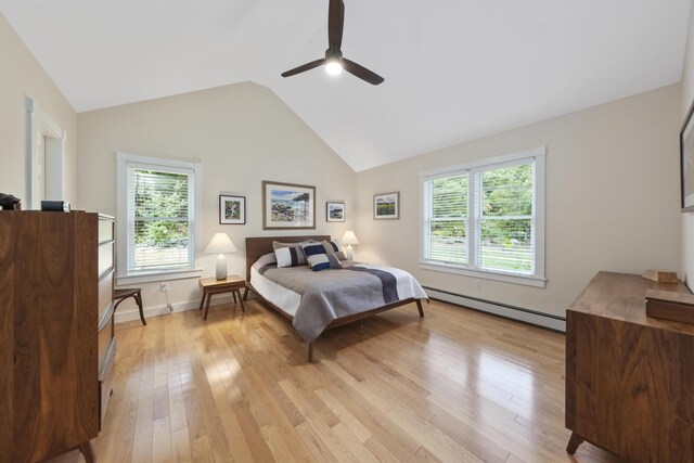 bedroom with ceiling fan, light hardwood / wood-style flooring, multiple windows, and a baseboard heating unit