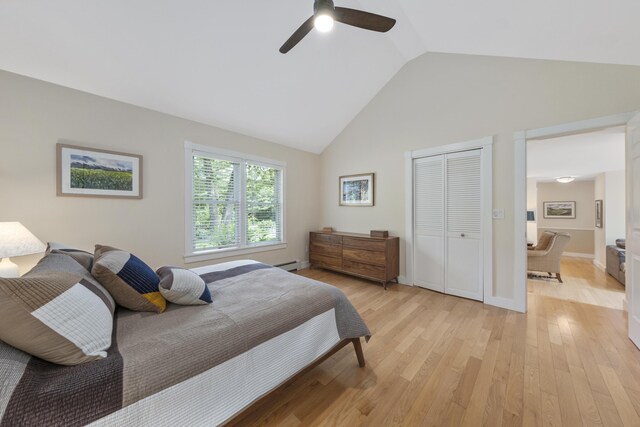 bedroom with light wood-type flooring, high vaulted ceiling, ceiling fan, and a closet