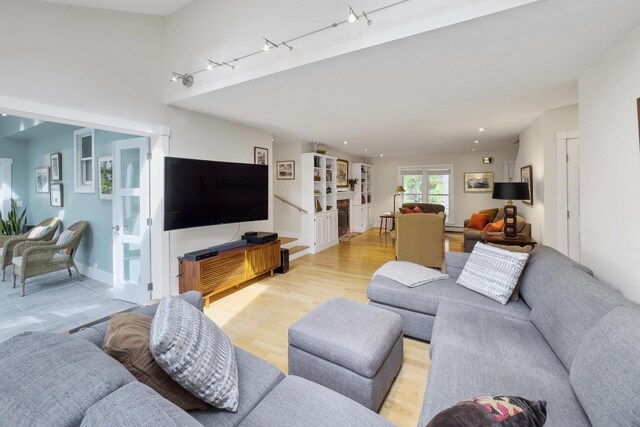 living room with light wood-type flooring and rail lighting