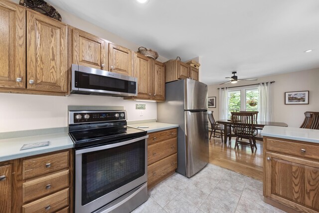 kitchen featuring light wood-type flooring, ceiling fan, and stainless steel appliances