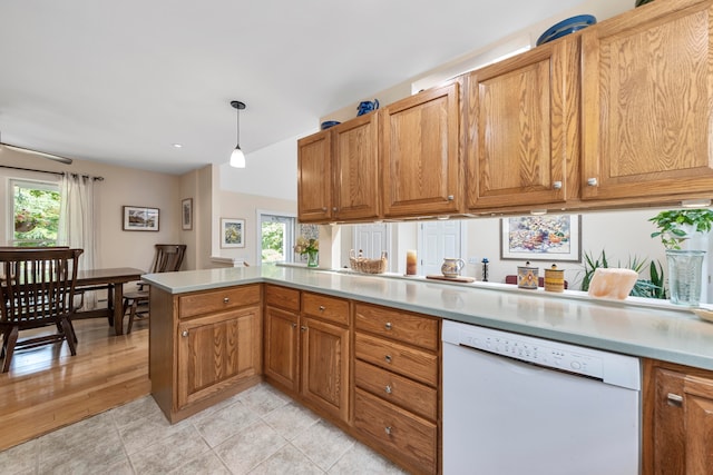 kitchen with dishwasher, decorative light fixtures, kitchen peninsula, and a wealth of natural light