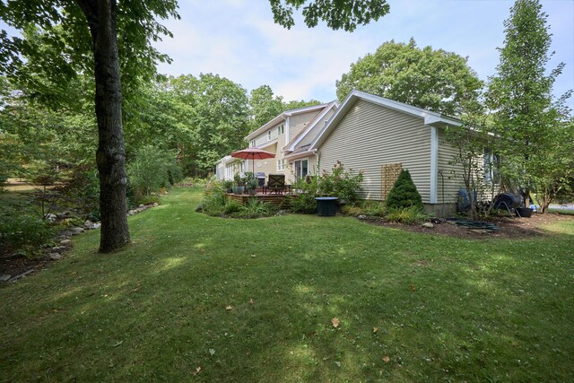 view of side of property featuring a lawn and a deck