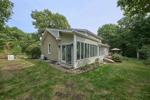 view of home's exterior with a lawn and a sunroom