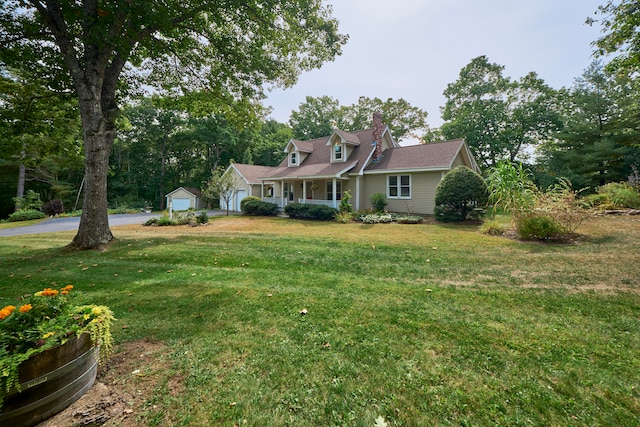 view of front facade featuring a front yard, an outbuilding, and a garage