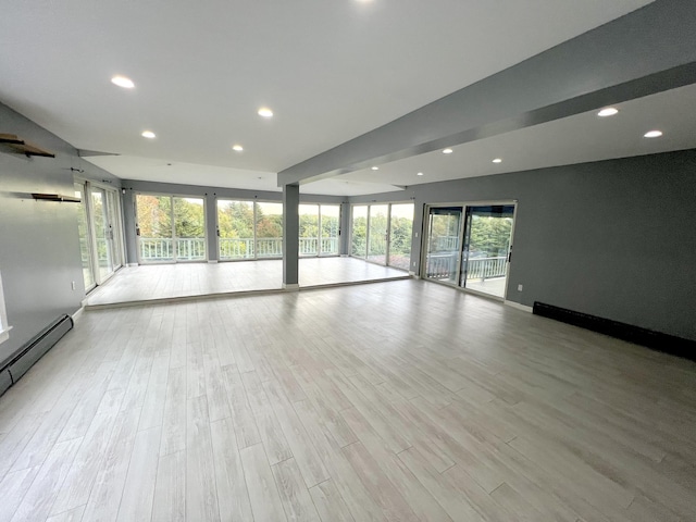 unfurnished living room with recessed lighting, baseboard heating, and wood finished floors