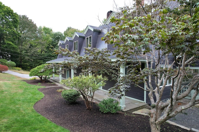 view of home's exterior with a chimney and a lawn