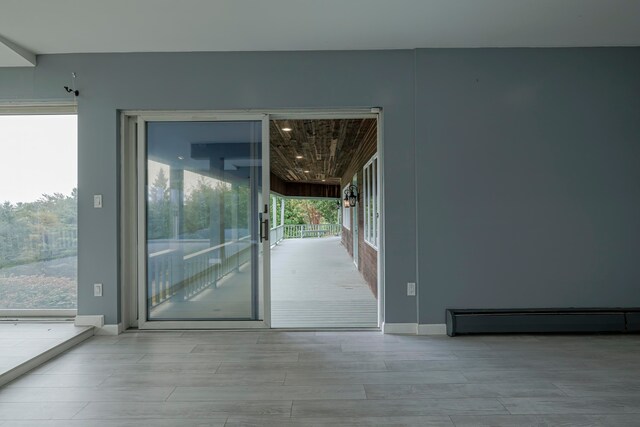 entryway featuring light wood-type flooring, plenty of natural light, and baseboard heating