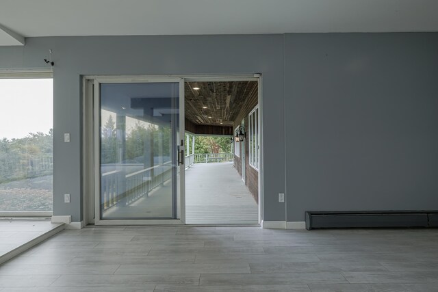 entryway with baseboard heating, wood finished floors, and baseboards