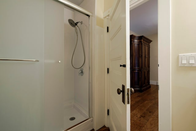 bathroom featuring hardwood / wood-style flooring and a shower with shower door