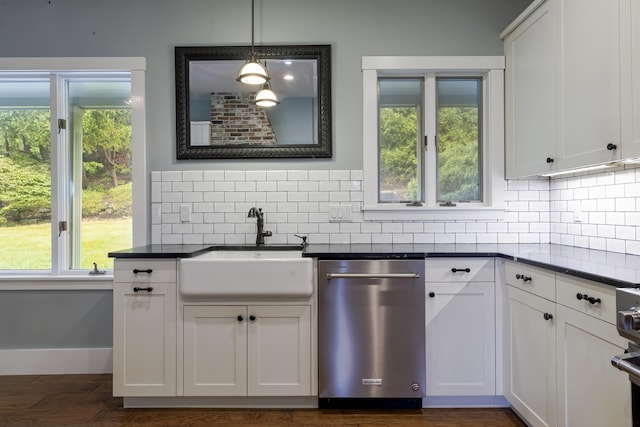 kitchen featuring tasteful backsplash, dishwasher, a sink, and dark countertops